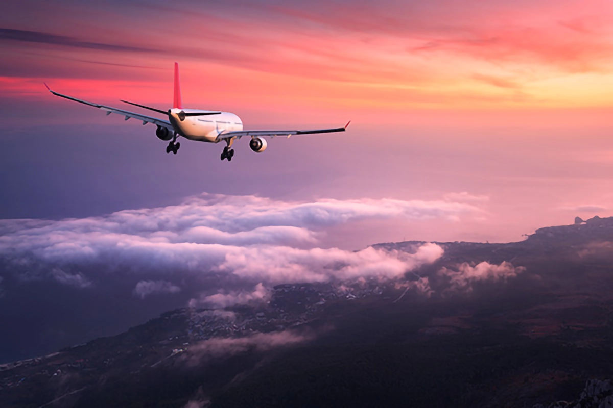 Image of a plane flying in a sunset